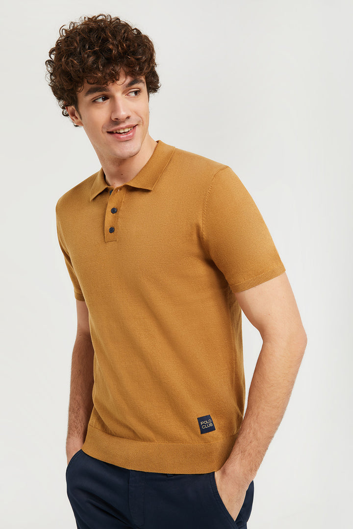 Polo de punto marrón con detalle en el bajo